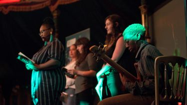 Five women perform on stage in a spiegeltent as part of the Writing for Resistance event at Festival of the Mind 2018