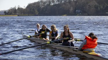 Students in rowing boat for Varsity rowing race in Peak District