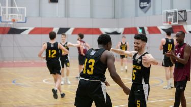 Students playing basketball at varsity event