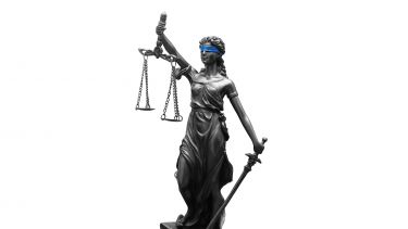 Statue of blindfolded woman holding scales