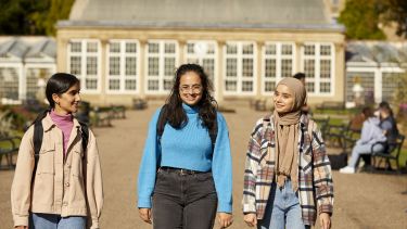 Three students walking in botanical gardens
