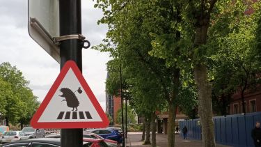 road sign in a car park warning that hedgehogs cross in the area