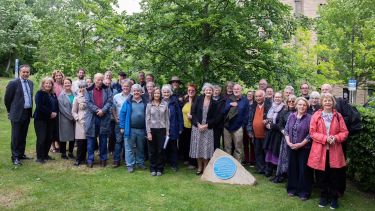 A photo of a group of people stood next to the newly unveiled blue heritage plaque for Ethel Haythornthwaite 