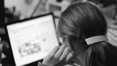 A woman looks at a laptop