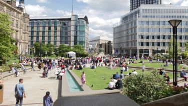Groups of people sitting in the Sheffield Peace Gardens
