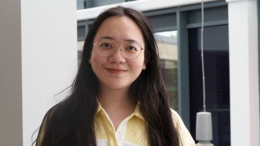 Xinyi Huang wearing a yellow and white shirt.