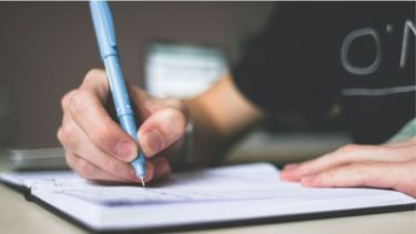 An image of someone writing in a notebook