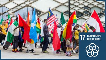 students with global flags with sdg17 logo overlaid