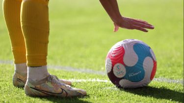 A Sweden player puts the football down