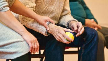 A nurse supporting an elderly man.