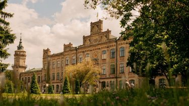 A grand building at the KPI campus in Kyiv, before the war with beautiful green gardens and trees