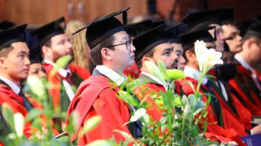Postgraduates red gowns in hall