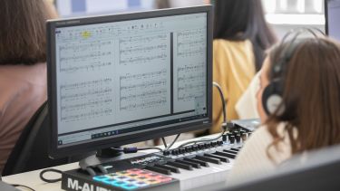 Class sat a computers creating music