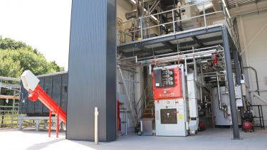 some large pieces of research equipment - which look like large grey, red and white boxes - are housed in a large warehouse-style building. These will carry out the testing for the project. 