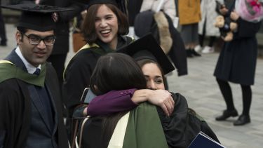 Two graduates hugging