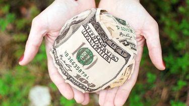 A woman offering a ball of money.