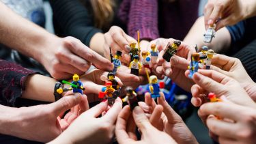People holding miniature figurines
