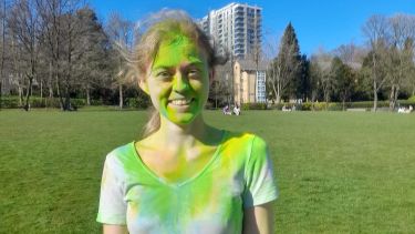 Politics student Joanna covered in green powder paint during a celebration of Holli in Sheffield