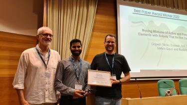 Photo of Gopesh Yadav Dosieah receiving award for Best Paper from conference chairs Dr Marco Dorigo and Professor Heiko Hamann  