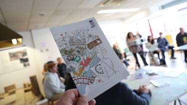 A hand holding a Castlegate postcard - a way for the public to provide feedback about the future of the site. 