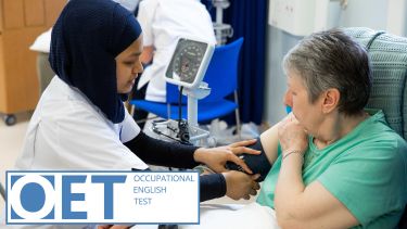 A imagine of a female healthcare worker placing a blood pressure monitor onto the right arm of a female patient with the OET Occupational English Test logo in the lower left corner