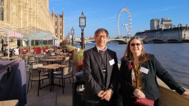 Professor Cordiner and Professor Zhu stand by the Thames with the London Eye behind them