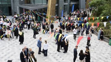 Busy area outside students union with graduates