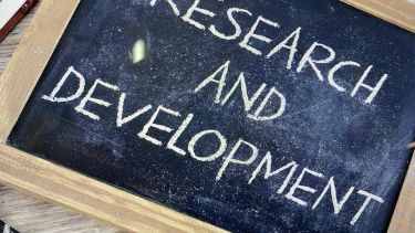 An image of a chalk board with 'research and development' written upon it in white chalk