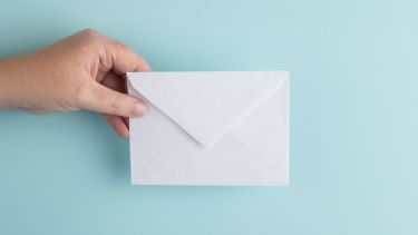 a hand holding an envelope against a blue background