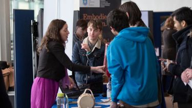 An individual explaining a festival exhibition to others