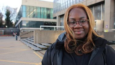Scholarship student Osa standing outside the Arts tower