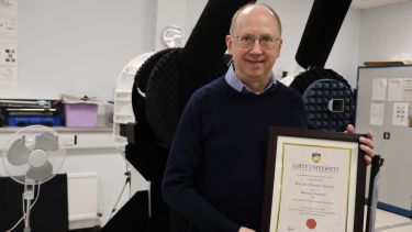 Photograph of Professor Tim O'Farrell with certification of his Honorary Professorship with Amity University in India