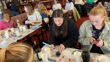 A photo of members of SocSoc at a charity tile painting event. 