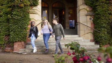 Three students walking down the steps at Firth Court 
