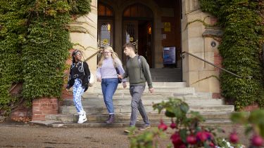Three students walking down the steps at Firth Court