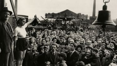 Boxer Barbara Buttrick in front of fairground crowd 