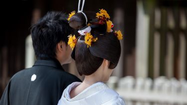 Two people taking part in a Japanese wedding.