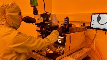 Photograph of PhD student(Tarick Blain) performing photolithography in the department's Class 5 yellow room using the LED mask aligner.