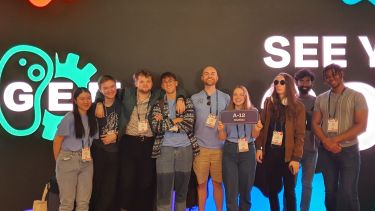 A group of students stood in front of a large screen at iGEM
