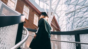 William Zheng in graduation gown in the Hearstpace