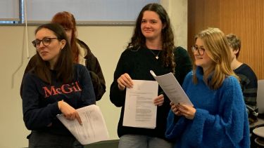 Three students acting with script in their hands