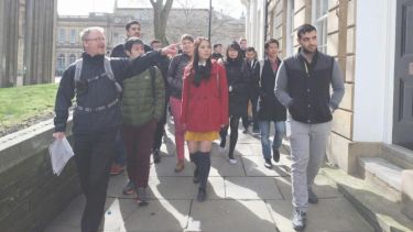 A group of students on a walking tour on a city street