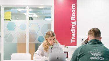 A student sat at a table outside the Trading Room.
