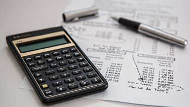 A finance sheet, a pen and a calculator.
