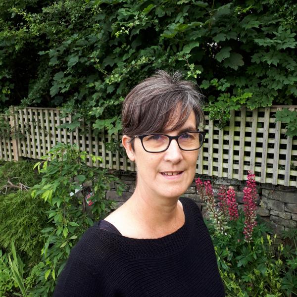 Profile picture of Dr Paula Meth in garden by a wooden fence