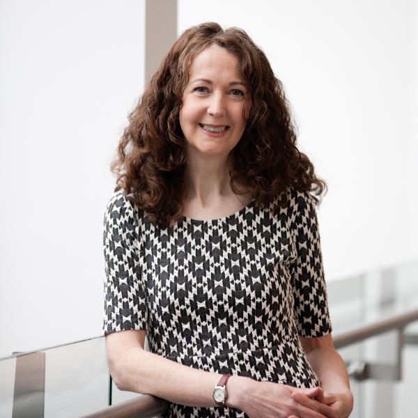 Profile picture of A head and shoulders photograph of Caroline Oates stood on the mezzanine in the Management School.