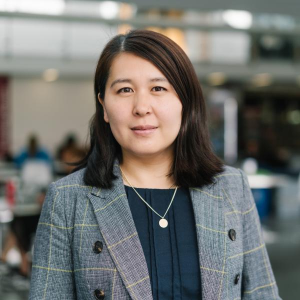 Profile picture of Jiao Ji wearing a dark top and a grey patterned jacket.