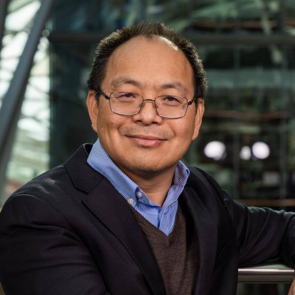 Profile picture of Professor Meihong Wang smiles as he stands in the Engineering Heartspace