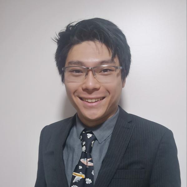 Profile picture of A man with dark hair and glasses is smiling at the camera, he is wearing a shirt and a tie with aeroplanes on.