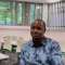 Alumnus Adamu sits in classroom being interviewed